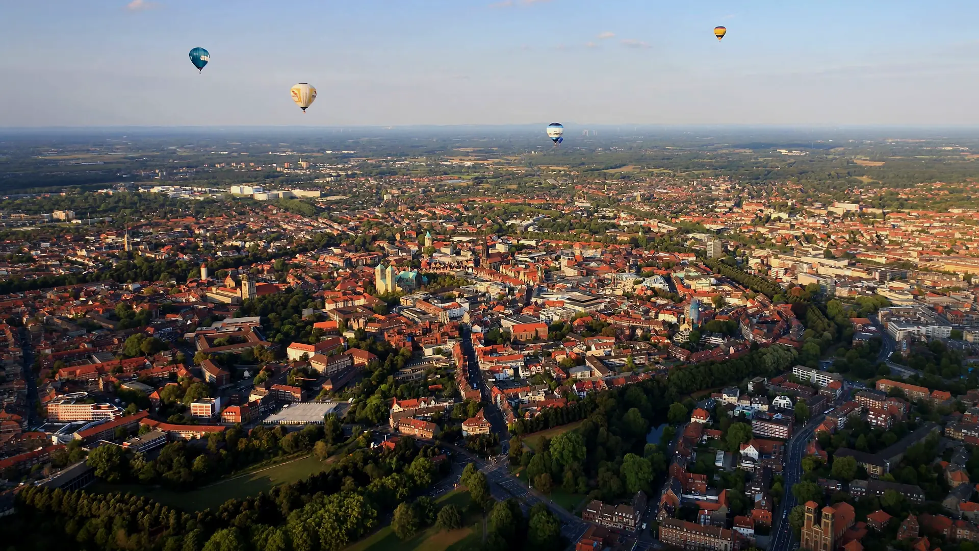 Münster aus der Luft, im Morgenlicht, mit Heißluftballons über der Stadt